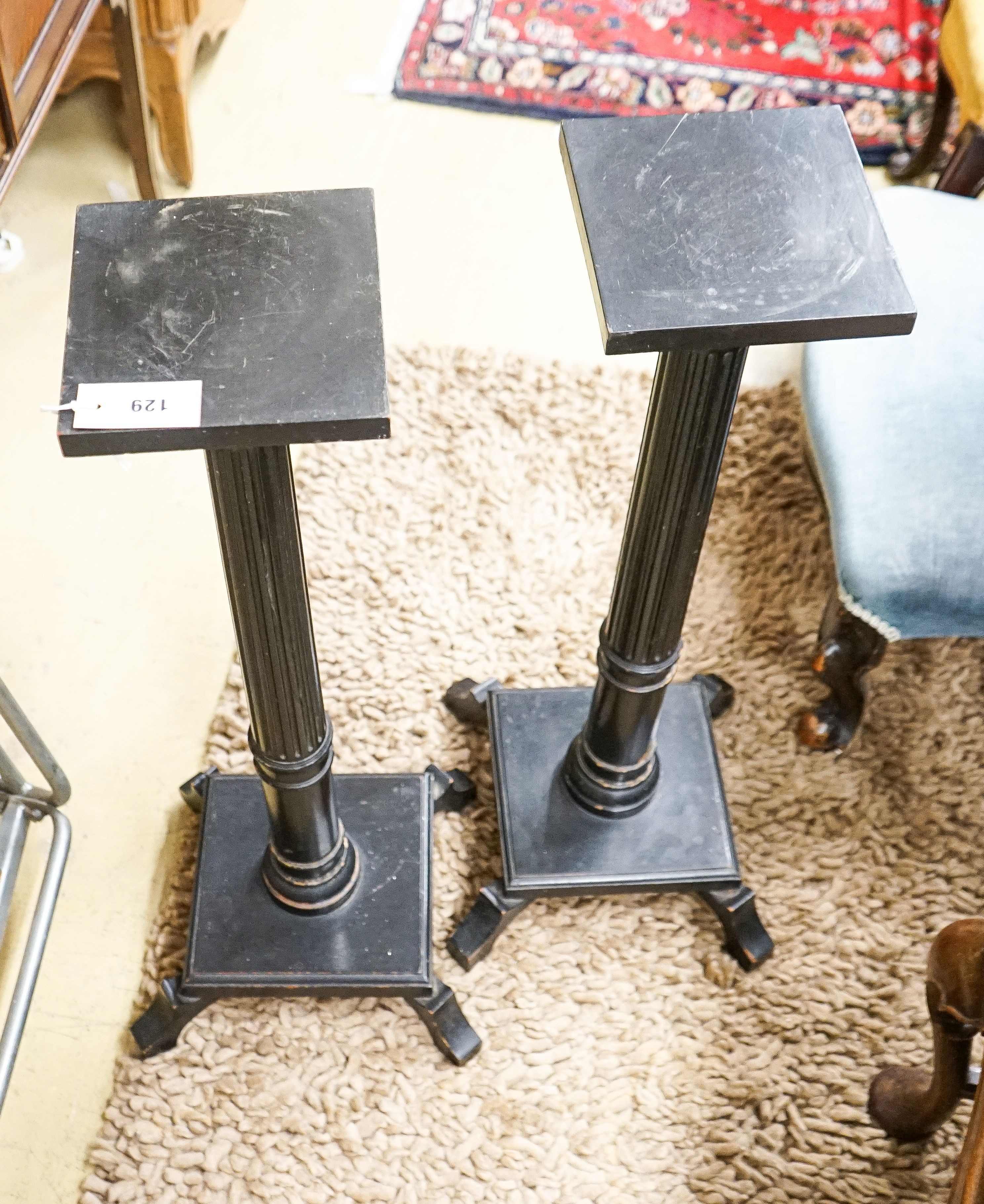 A pair of fluted ebonised plant stands, height 80cm